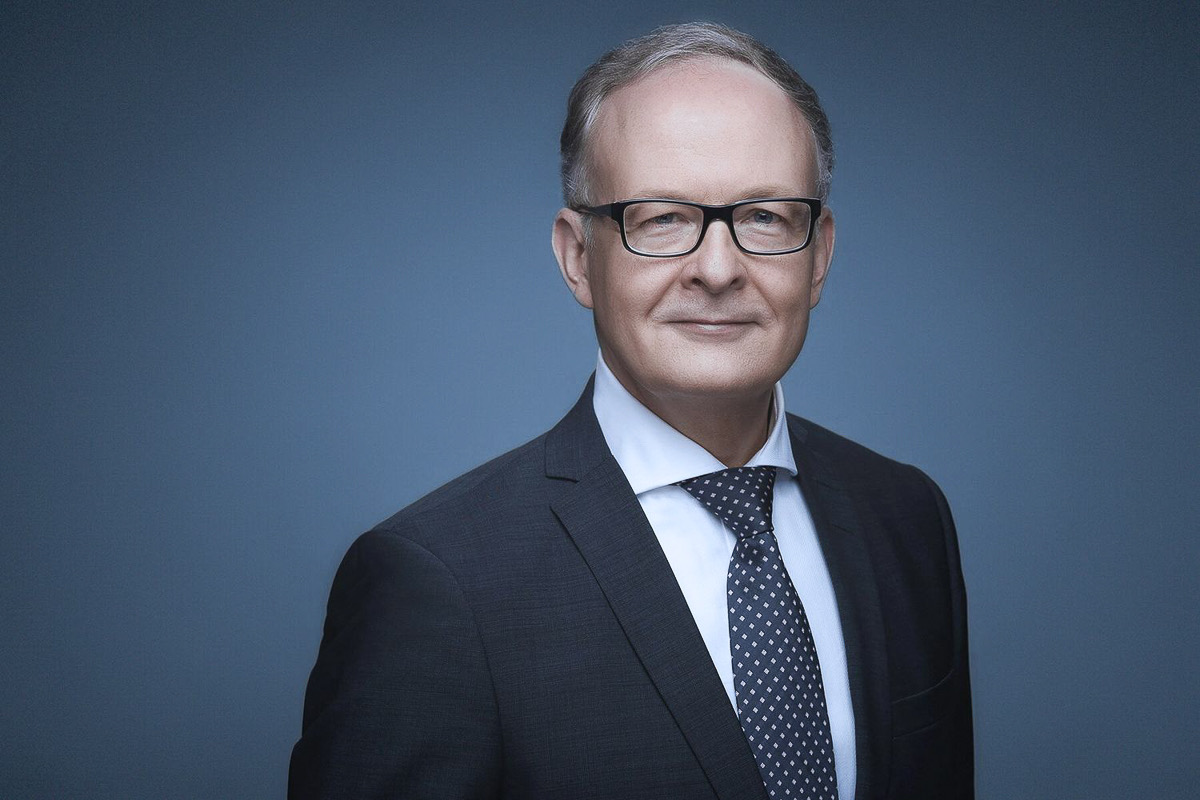 Businessportrait eines Geschäftsführers vor blaugrauem Studiohintergrund